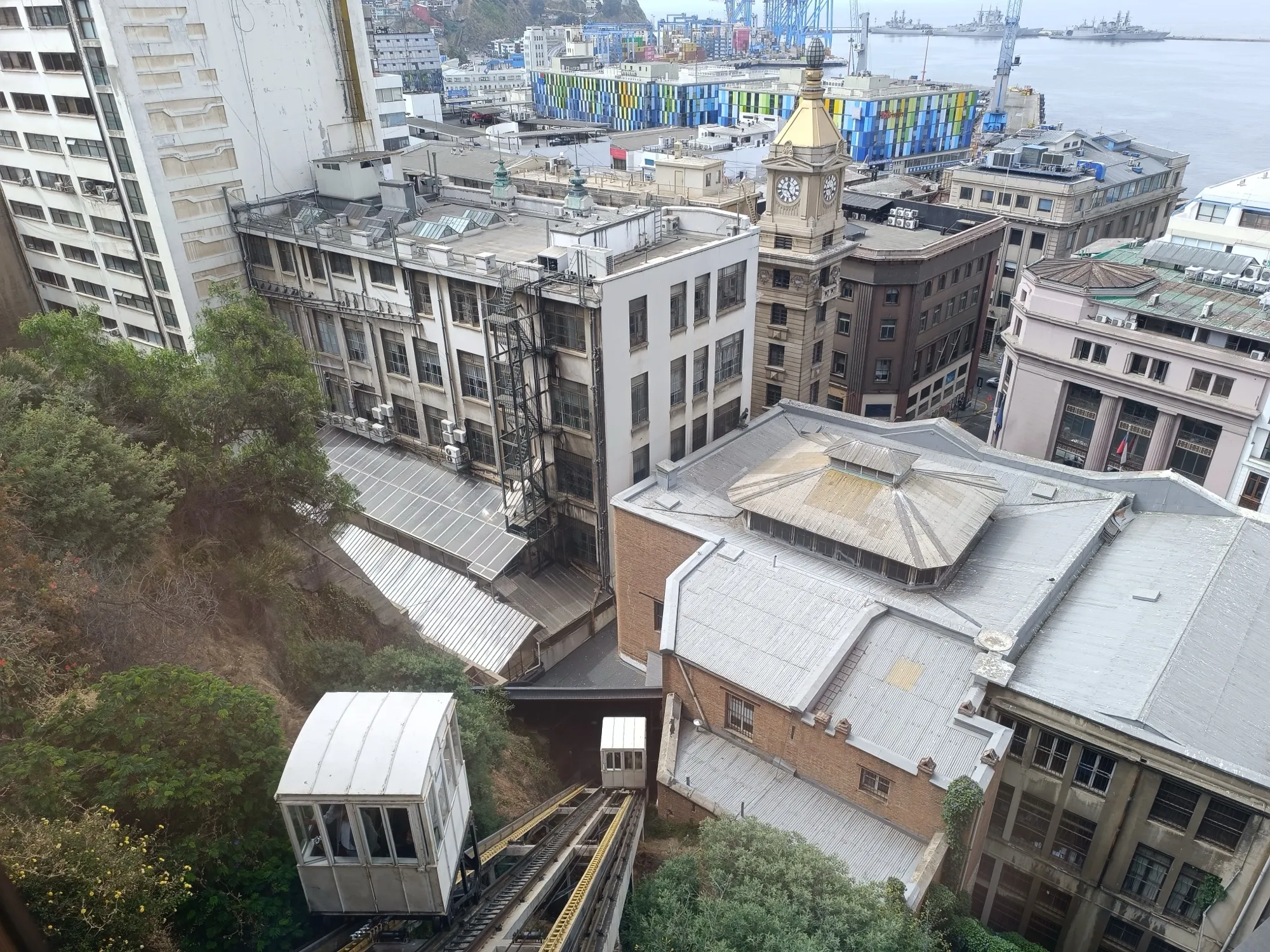 Vista desde lo alto del Ascensor Concepción: el vagón sobre los rieles del cerro, entre edificios y con el mar al fondo