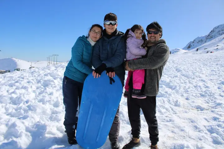 Familia con un trineo en la nieve de la cordillera de los Andes