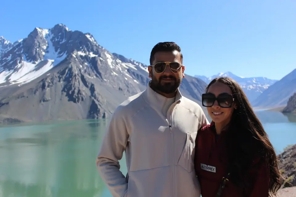 Pareja frente al Embalse El Yeso en un tour de día completo desde Santiago