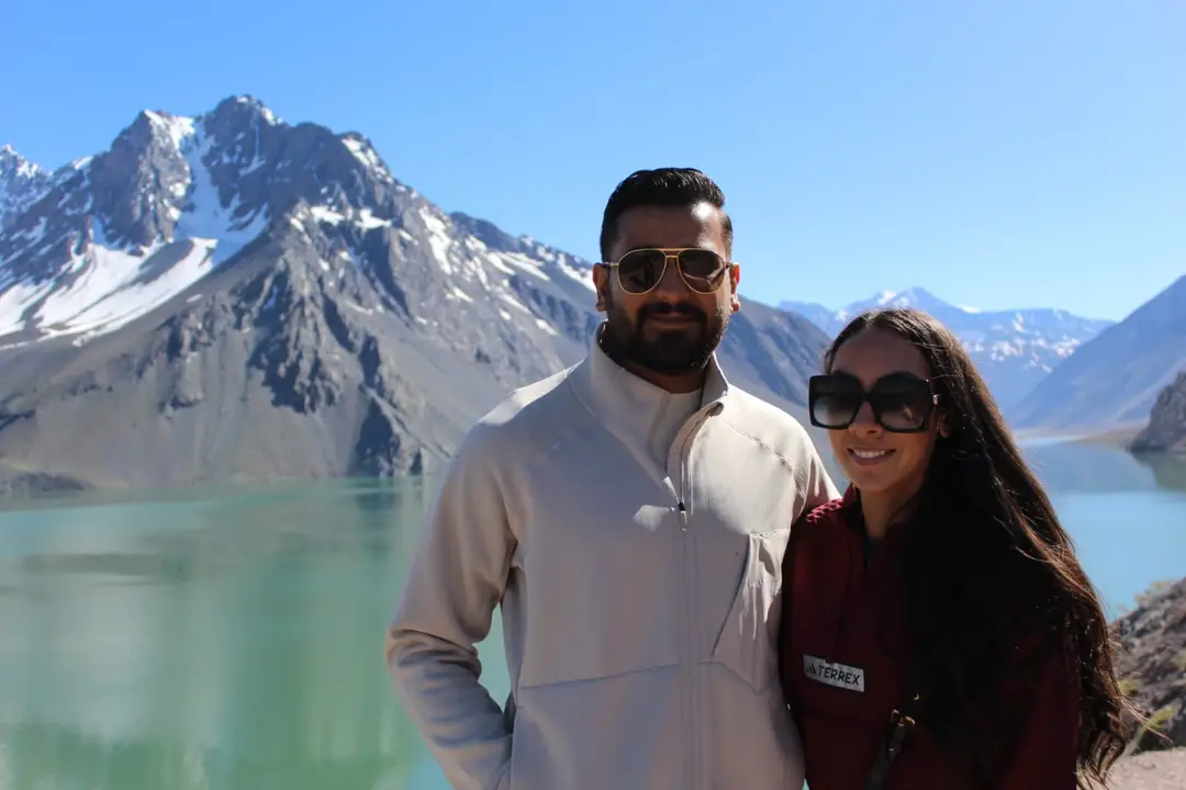 Pareja frente al Embalse El Yeso en un tour de día completo desde Santiago