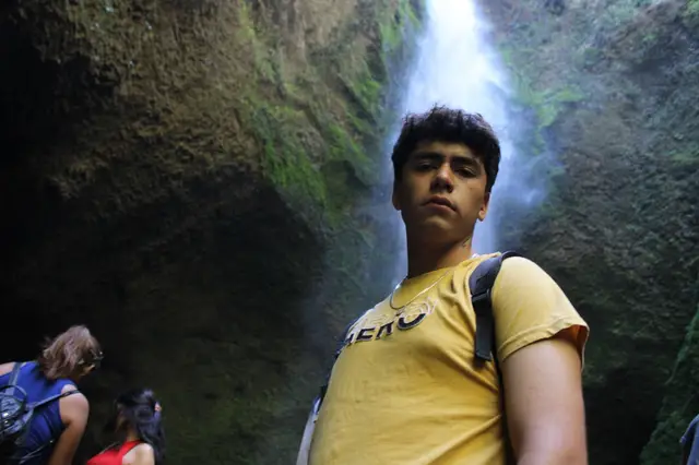 Excursionista bajo un salto de agua en la Reserva Biológica Huilo Huilo