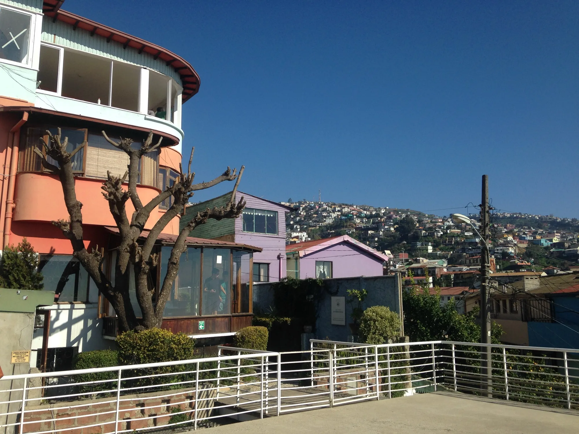 La Sebastiana, la casa de Neruda en Valparaíso, con paredes de color rojizo y terrazas, y los cerros de la ciudad a la derecha