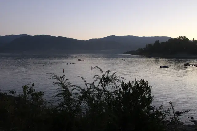 Atardecer en el Lago Calafquén, con personas disfrutando del agua en la Araucanía