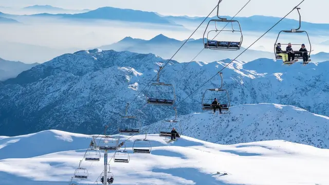 Telesillas sobre montañas nevadas de la cordillera de los Andes
