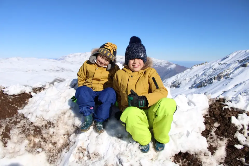 Niños jugando en la nieve durante un tour privado a la cordillera de los Andes