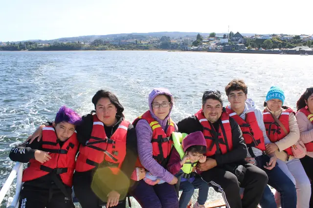 Familia disfrutando de un paseo en bote por un lago del sur de Chile