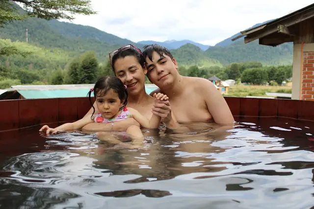 Familia relajándose en las termas de Liquiñe, rodeados de naturaleza