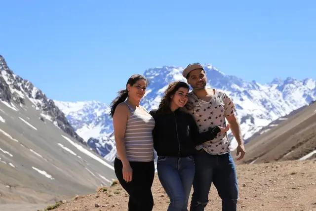 Tres personas posando frente a montañas nevadas junto a las termas