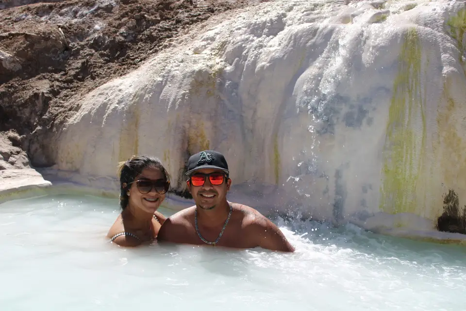 Pareja en una piscina termal de travertino blanco en el Valle de Colina