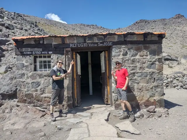 Dos excursionistas frente a un refugio de piedra en la ruta